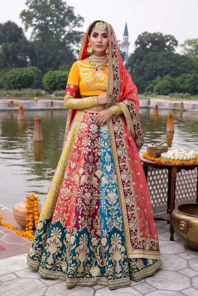 Bride wearing a vibrant pink ghagra choli with mirror work at a Sangeet ceremony.