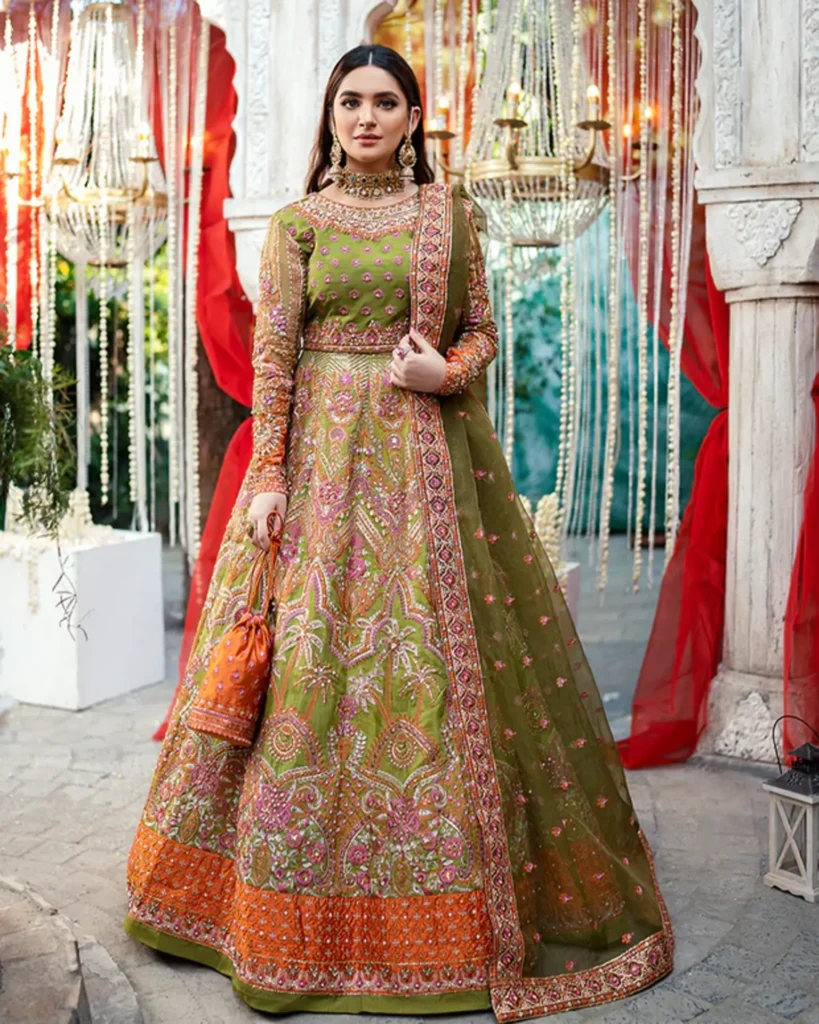 Bride wearing a vibrant pink ghagra choli with mirror work at a Sangeet ceremony.